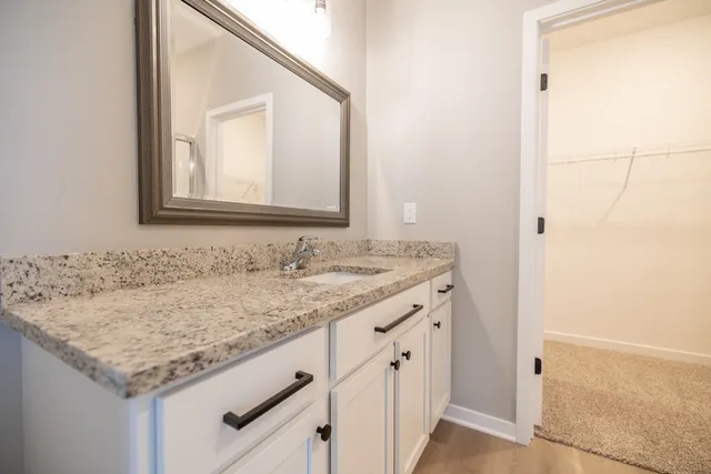 a bathroom with a granite countertop sink and a mirror