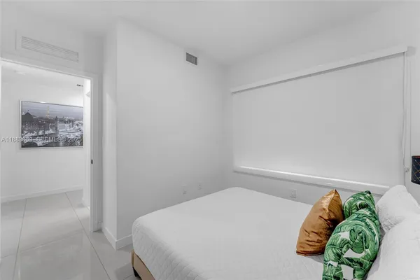 a bedroom with a bed and a painting on the wall