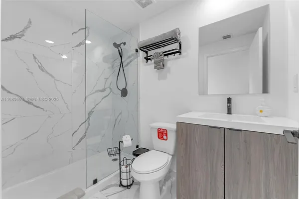 a bathroom with a sink vanity mirror and toilet