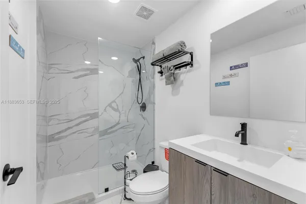 a bathroom with a sink toilet vanity and shower