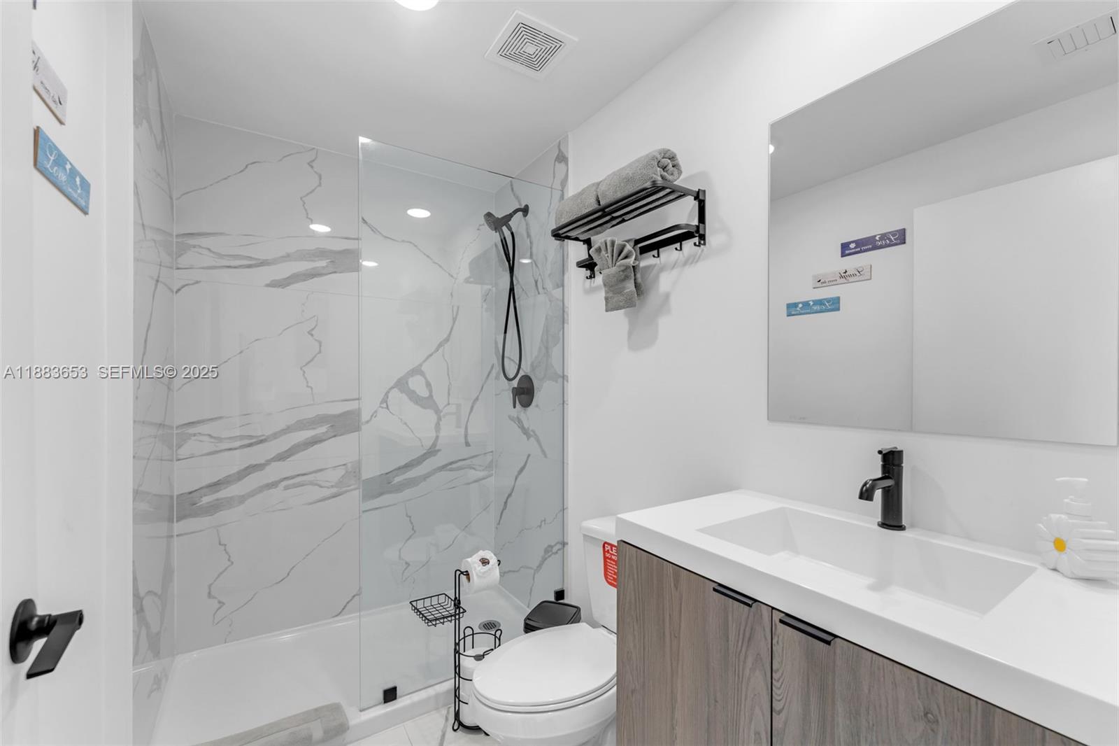 26144 Southwest 146th Court Homestead, FL 33032 - Photo 19 of 35 Elegant en-suite bathroom with glass shower and marble-style walls.