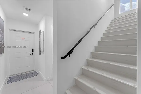 a view of entryway with wooden floor and stairs