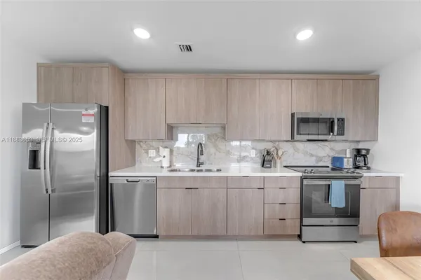 a kitchen with stainless steel appliances granite countertop a refrigerator sink and cabinets