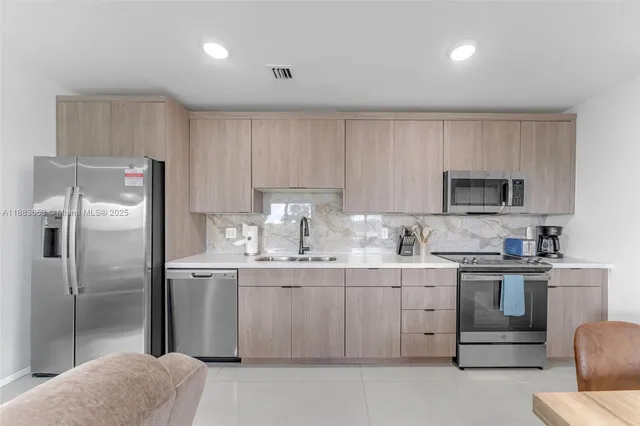a kitchen with stainless steel appliances granite countertop a refrigerator sink and cabinets