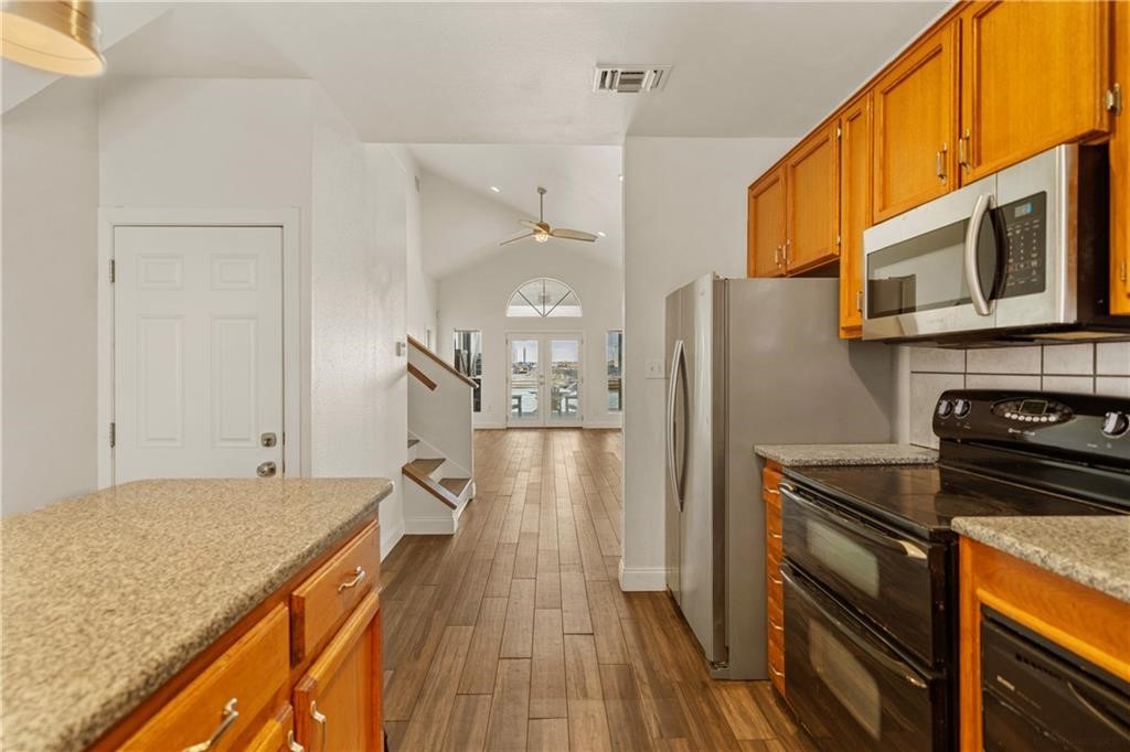 741 Snug Corpus Christi, TX 78402 - Photo 14 of 40 a kitchen with stainless steel appliances granite countertop a refrigerator and a stove top oven