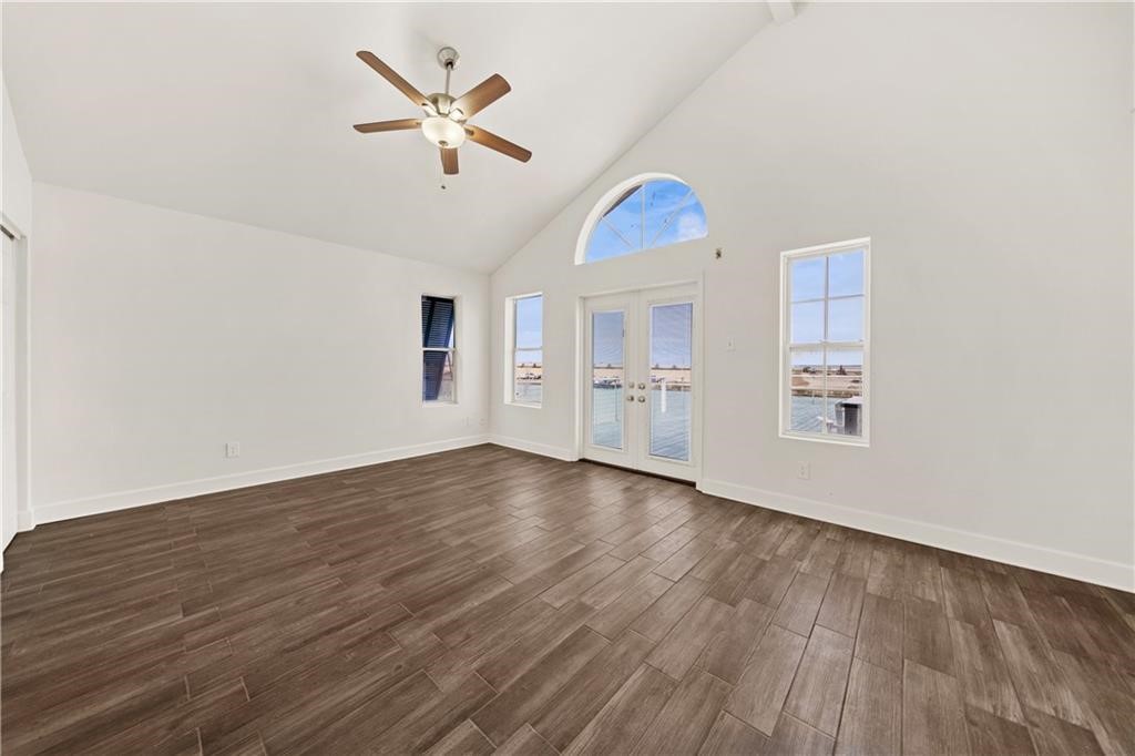 741 Snug Corpus Christi, TX 78402 - Photo 17 of 40 an empty room with wooden floor ceiling fan and windows
