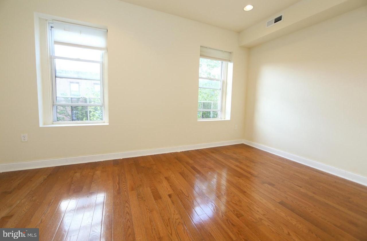 1708 West Diamond Street, Unit B Philadelphia, PA 19121 - Photo 16 of 20 a view of an empty room with wooden floor and a window