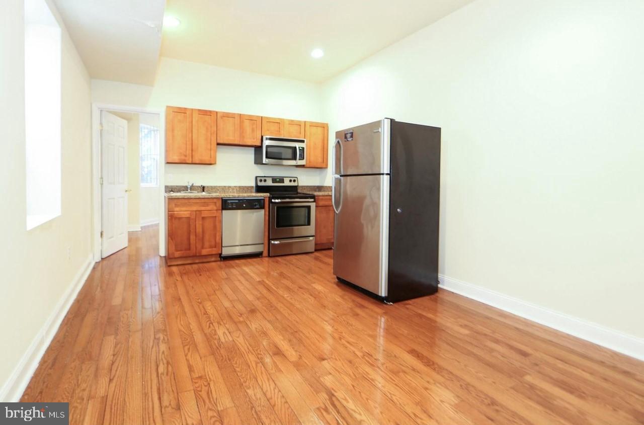 1708 West Diamond Street, Unit B Philadelphia, PA 19121 - Photo 2 of 20 a kitchen with stainless steel appliances a refrigerator and a stove top oven
