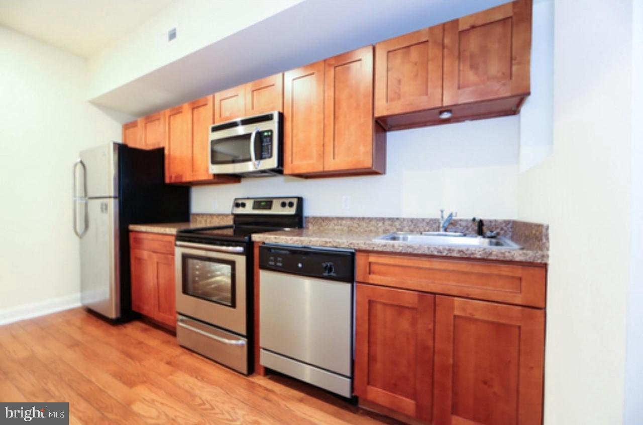 1708 West Diamond Street, Unit B Philadelphia, PA 19121 - Photo 4 of 20 a kitchen with stainless steel appliances granite countertop a stove a sink and a refrigerator