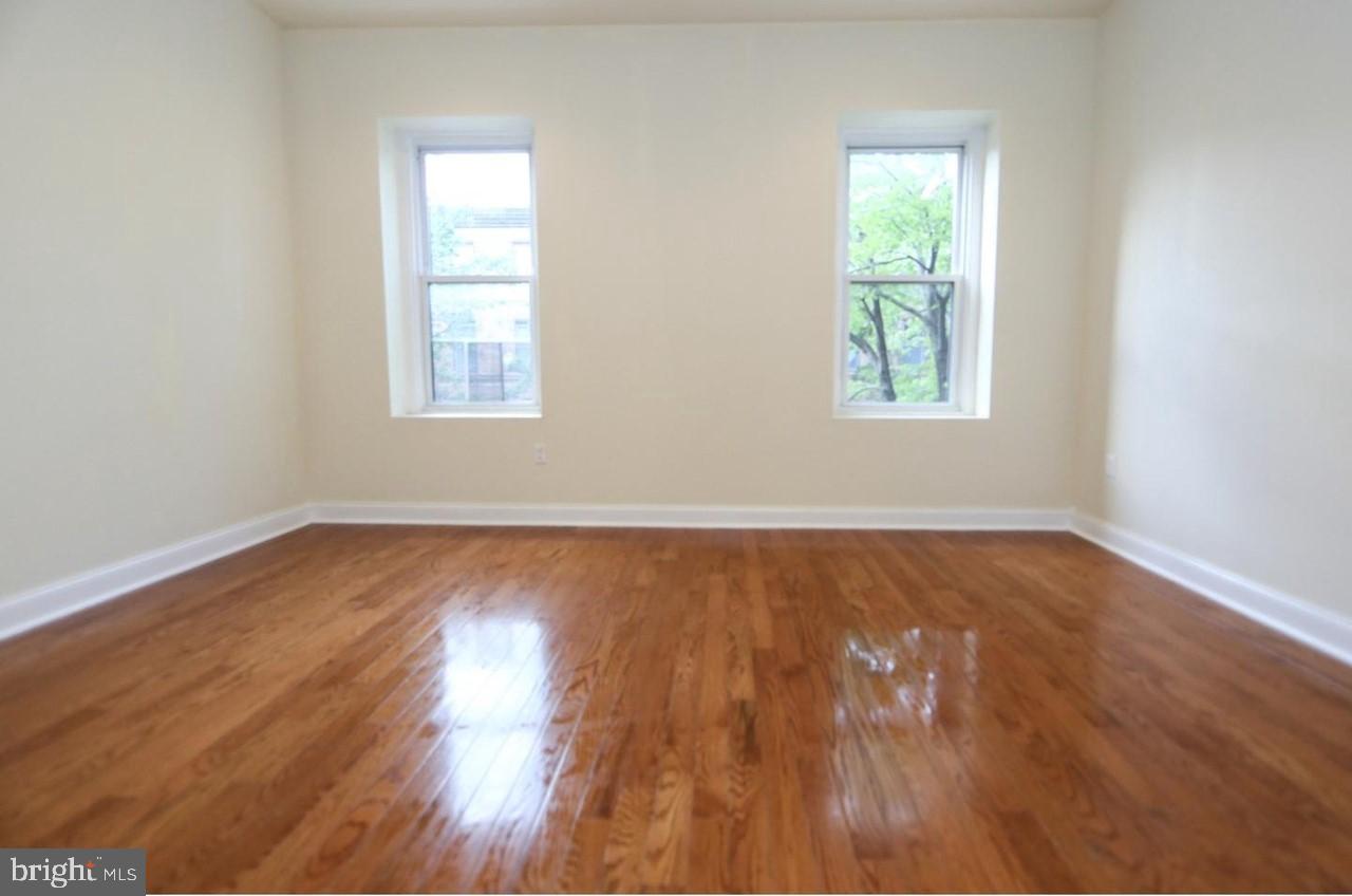 1708 West Diamond Street, Unit B Philadelphia, PA 19121 - Photo 5 of 20 an empty room with wooden floor and windows