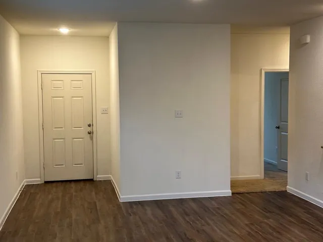 an empty room with wooden floor and closet area