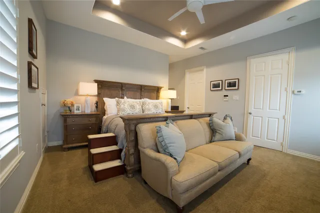 an empty room with chandelier fan and windows