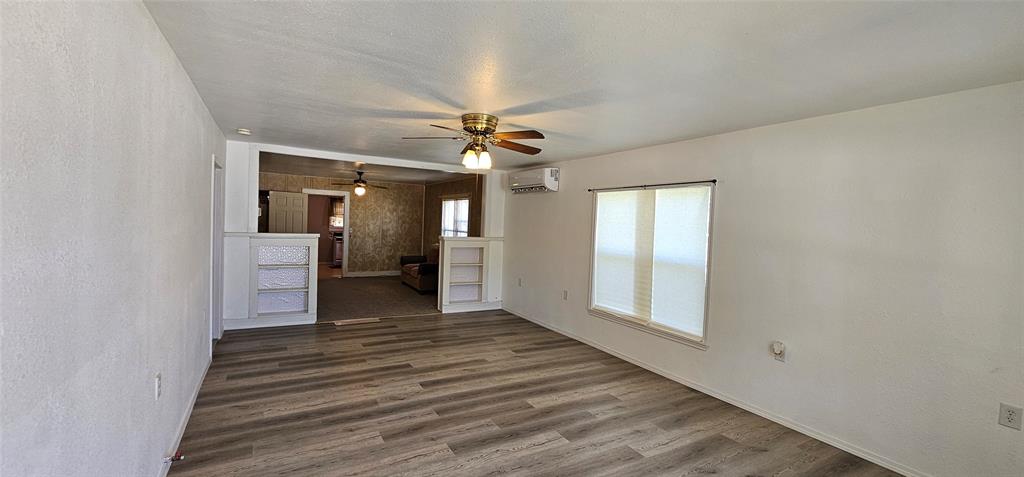 501 South Main Street Eden, TX 76837 - Photo 2 of 20 a view of a hallway with wooden floor and a ceiling fan
