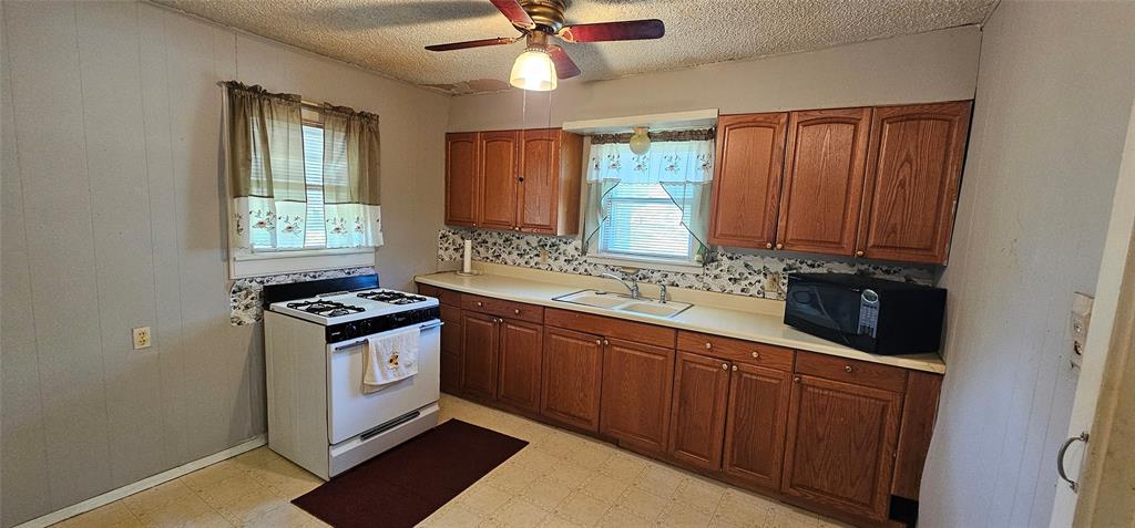 501 South Main Street Eden, TX 76837 - Photo 6 of 20 a kitchen with stainless steel appliances granite countertop a stove a sink and a microwave