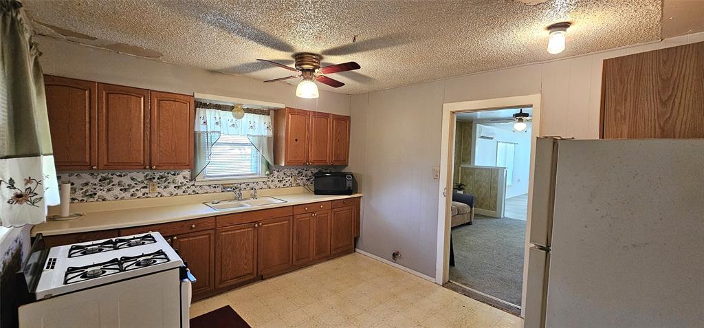 501 South Main Street Eden, TX 76837 - Photo 7 of 20 a kitchen with a stove a sink and a refrigerator