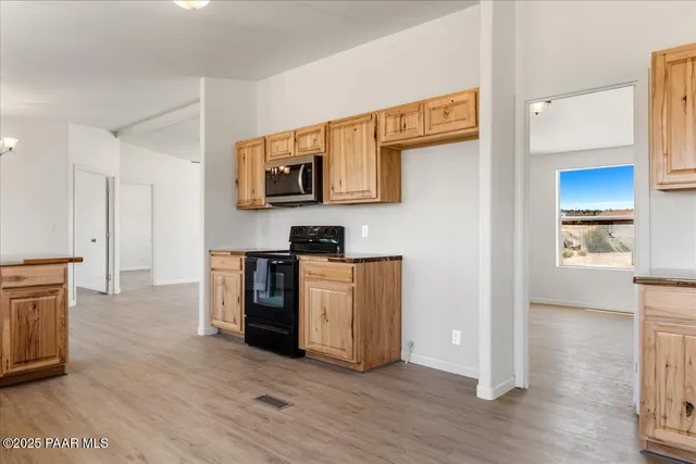 a large kitchen with stainless steel appliances granite countertop a lot of counter space and wooden floor