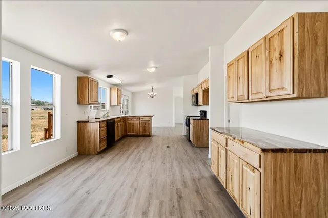 a view of an empty room with wooden floor fireplace and a window