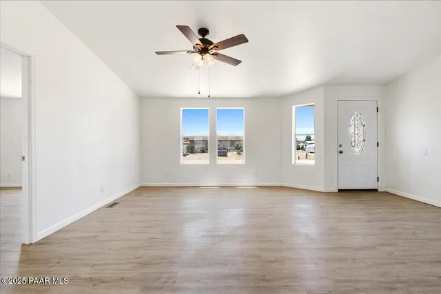 a large kitchen with cabinets wooden floor and stainless steel appliances