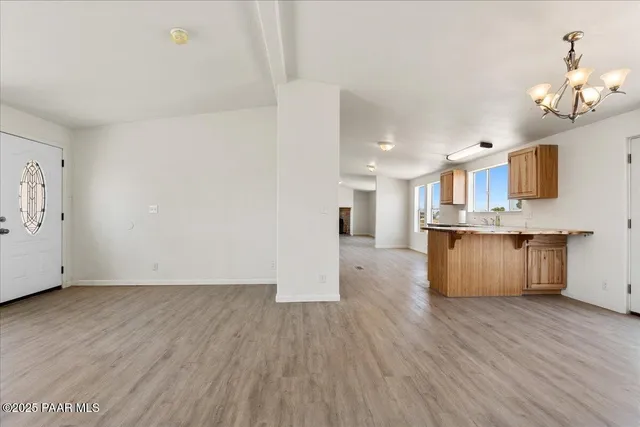 a large kitchen with a center island wooden floor and stainless steel appliances