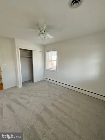 an empty room with windows and fan