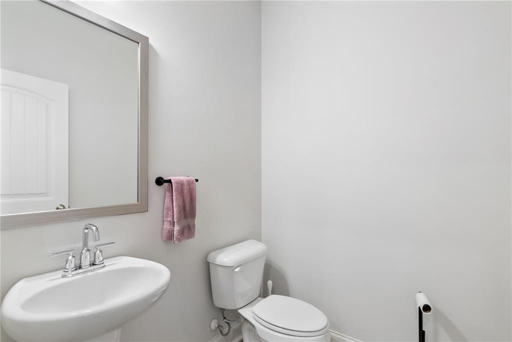 3334 Swallowtail Terrace Duluth, GA 30096 - Photo 19 of 27 a bathroom with a toilet a sink and mirror