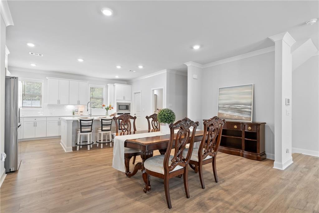 3334 Swallowtail Terrace Duluth, GA 30096 - Photo 6 of 27 a view of a dining room with furniture and wooden floor