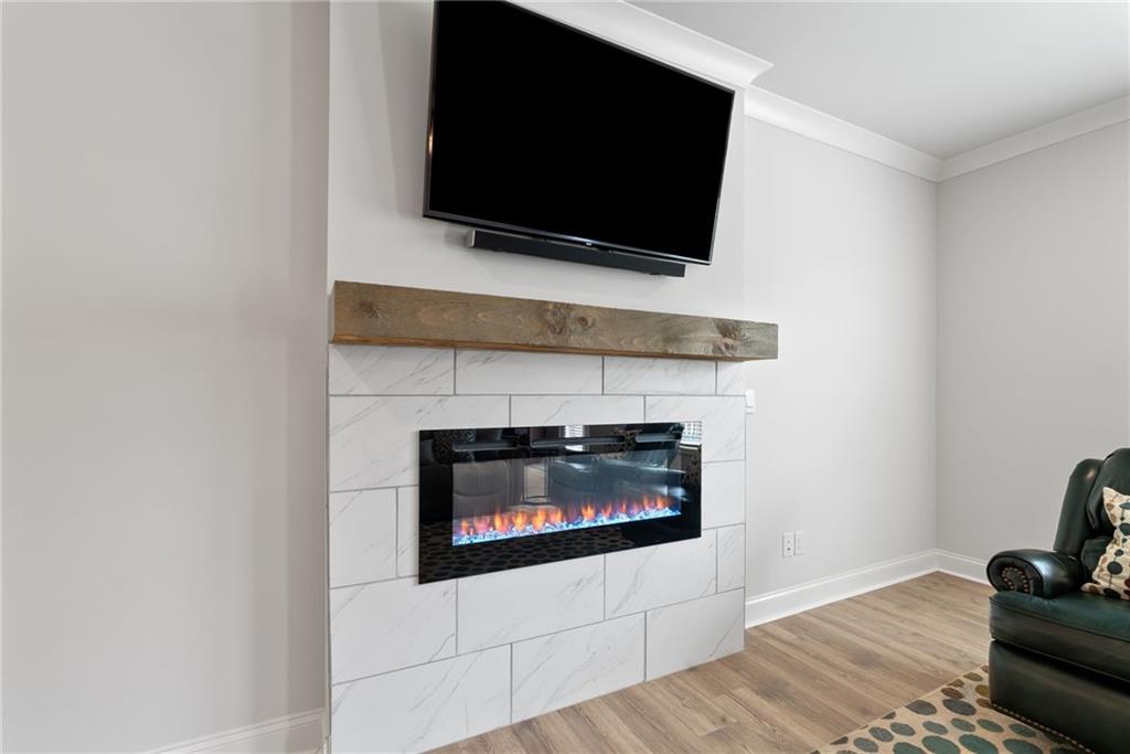 3334 Swallowtail Terrace Duluth, GA 30096 - Photo 8 of 30 a living room with a fireplace and a flat screen tv