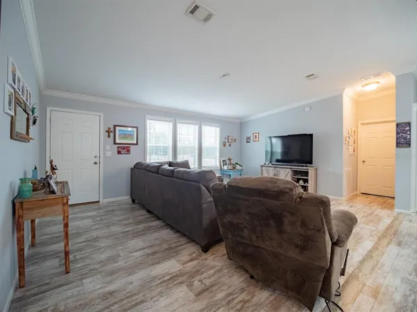 a living room with furniture flat screen tv and large windows
