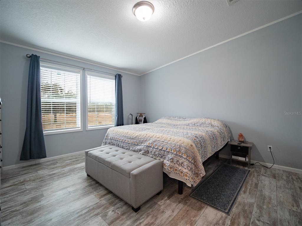 5431 163rd Path Live Oak, FL 32060 - Photo 26 of 49 a spacious bedroom with a bed and wooden floor