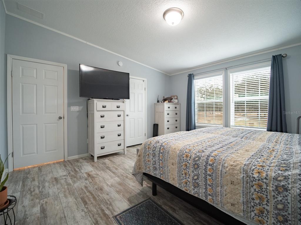 5431 163rd Path Live Oak, FL 32060 - Photo 29 of 49 a bedroom with a large bed and a flat tv screen on dresser