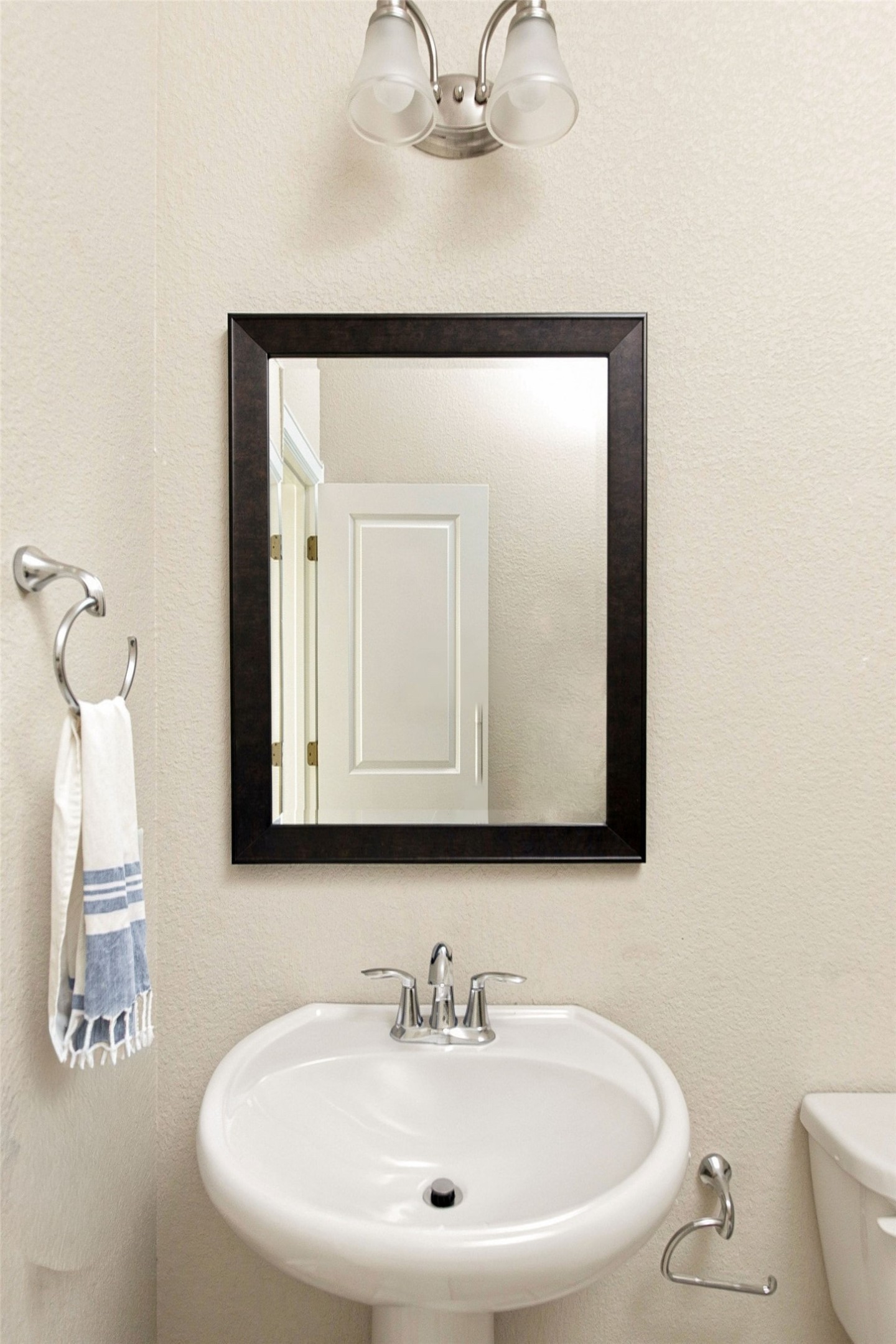 6100 Gunnison Turn Road Austin, TX 78738 - Photo 28 of 34 A classic white pedestal sink anchors this neutral bathroom space.