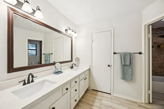 a bathroom with double vanity sink and mirror