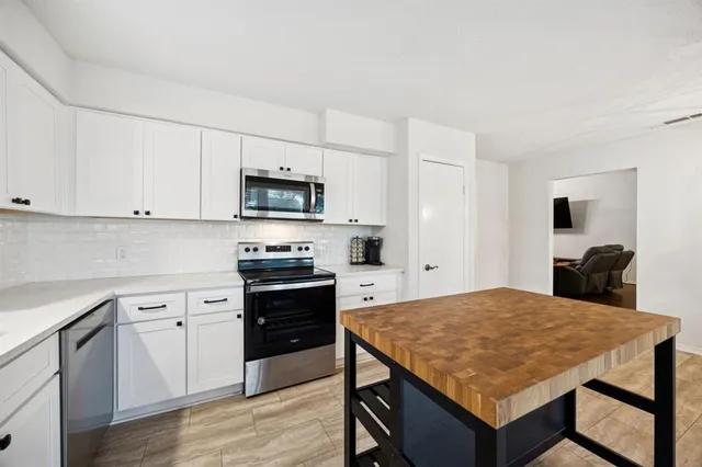 a kitchen with a stove a sink a microwave and wooden cabinets