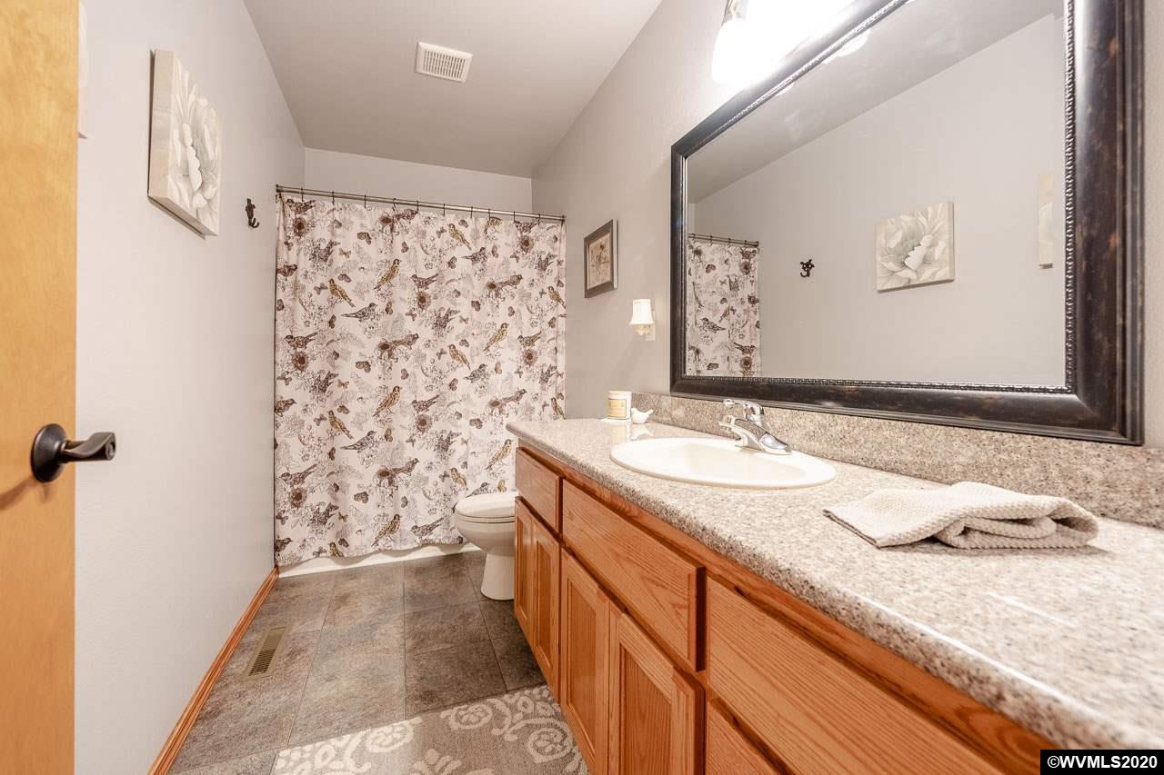 15241 Strong Road Dallas, OR 97338 - Photo 23 of 40 a bathroom with a granite countertop sink and a mirror