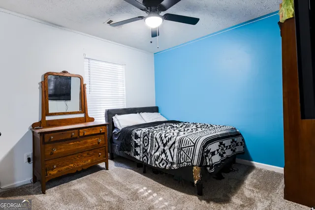 a bed sitting in a bedroom next to a window