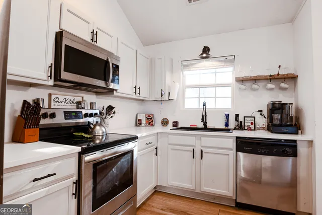 a kitchen with white cabinets and stainless steel appliances