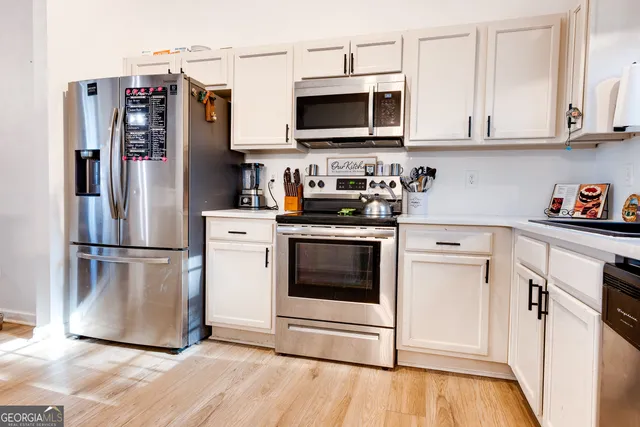 a kitchen with stainless steel appliances a stove microwave and refrigerator
