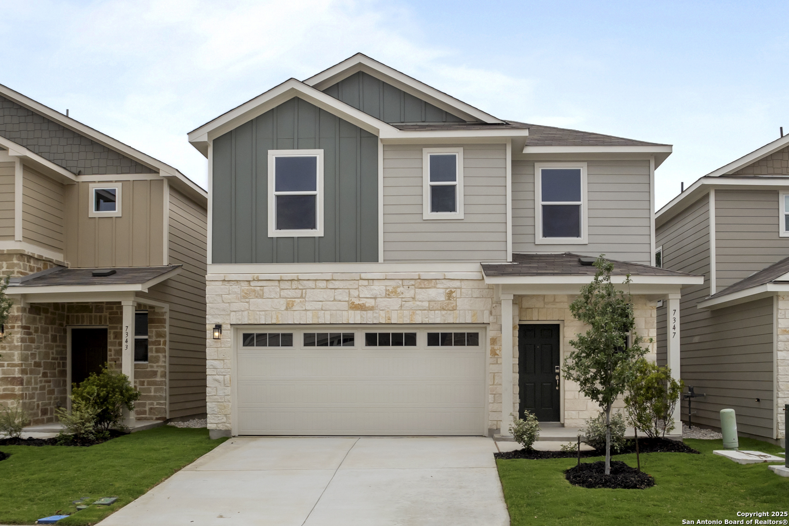 a front view of a house with a yard and garage