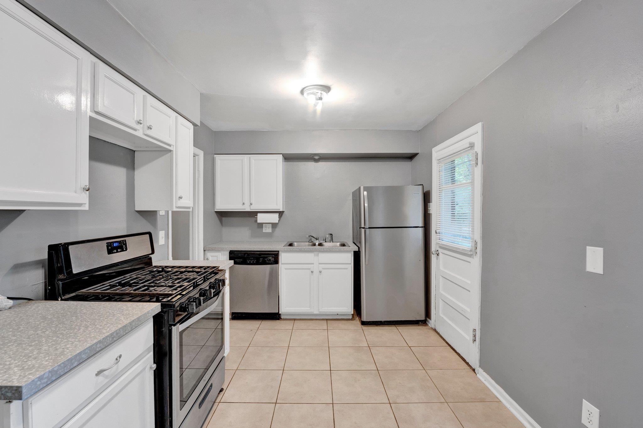 985 Wellsville Road Memphis, TN 38117 - Photo 19 of 24 a kitchen with a refrigerator a stove top oven and cabinets