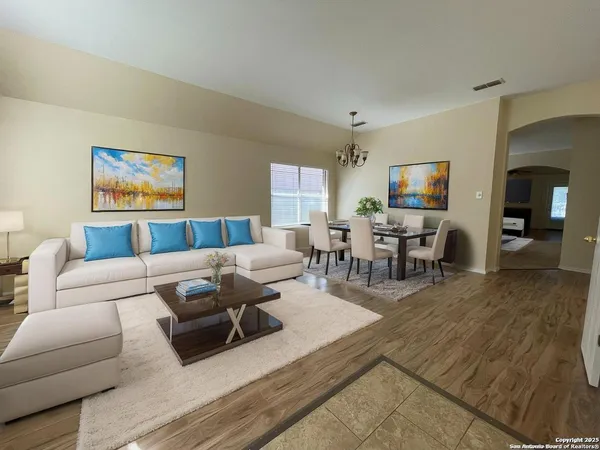 a living room with furniture wooden floor and a large window