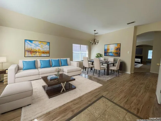 a living room with furniture wooden floor and a large window