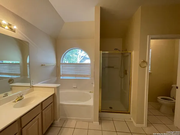 a spacious bathroom with a granite countertop sink a toilet and shower