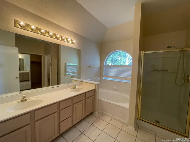 a bathroom with a double vanity sink a mirror and a shower