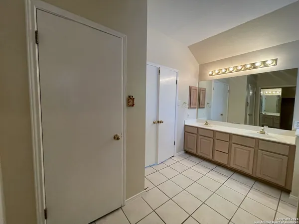 a large bathroom with a double vanity sink mirror and a bathtub