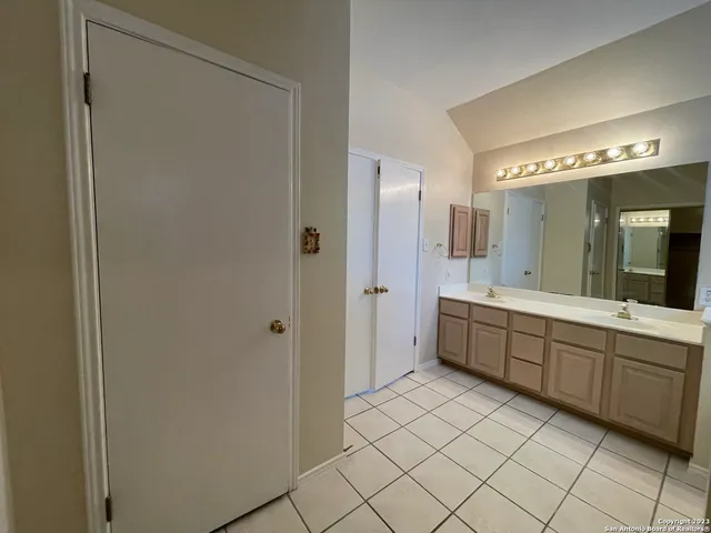 a large bathroom with a double vanity sink mirror and a bathtub