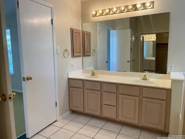 a bathroom with a double vanity sink and a mirror