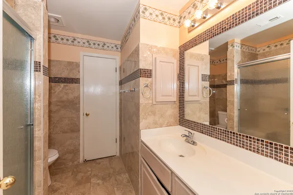 a bathroom with a tub shower and sink