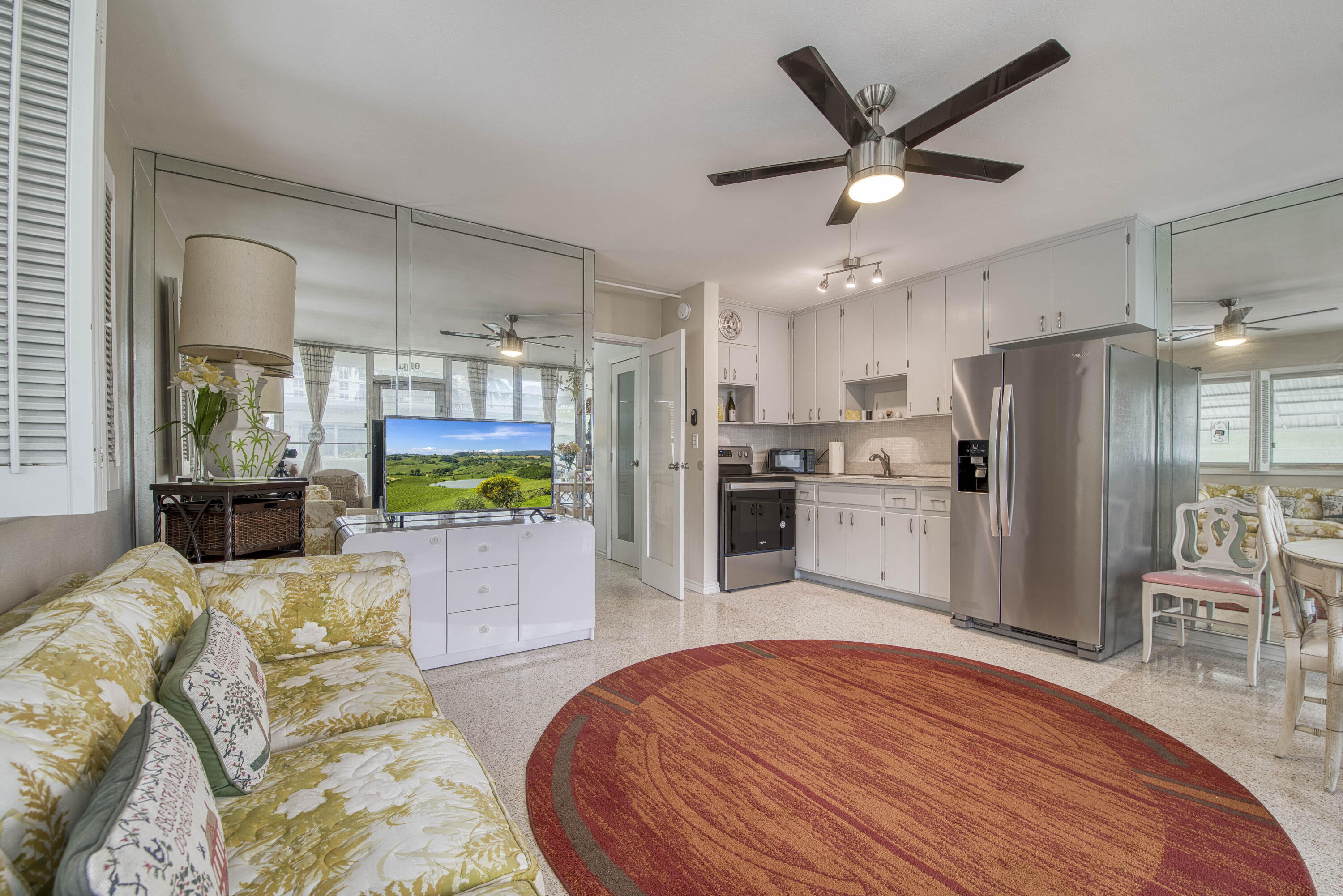 901 North Birch Road, Unit D10 Fort Lauderdale, FL 33304 - Photo 2 of 20 a kitchen with stainless steel appliances kitchen island granite countertop a refrigerator a stove a sink a dining table and chairs with wooden floor