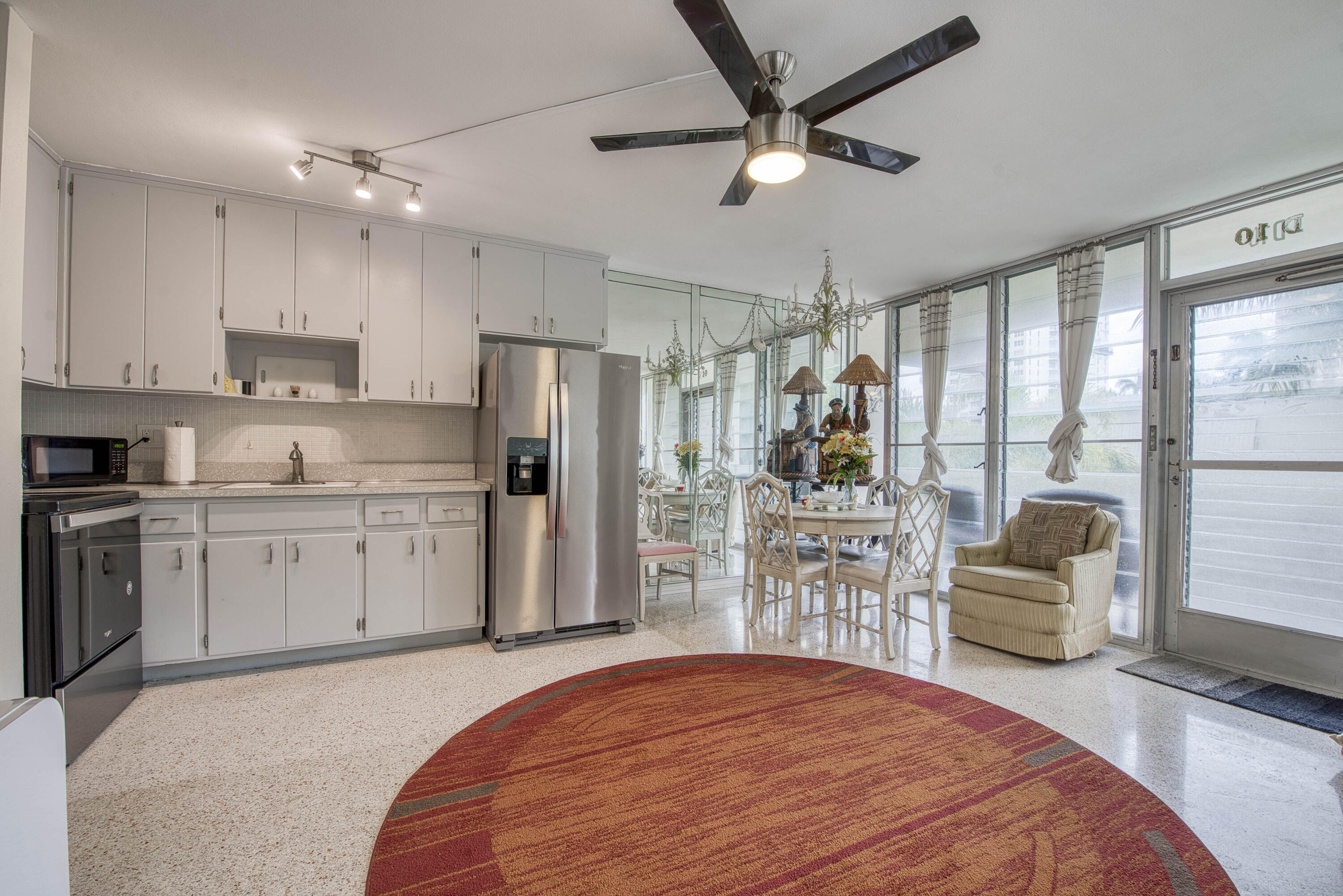 901 North Birch Road, Unit D10 Fort Lauderdale, FL 33304 - Photo 3 of 20 a kitchen with a refrigerator a stove top oven a sink a dining table and chairs with wooden floor