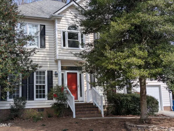 a front view of a house with a tree